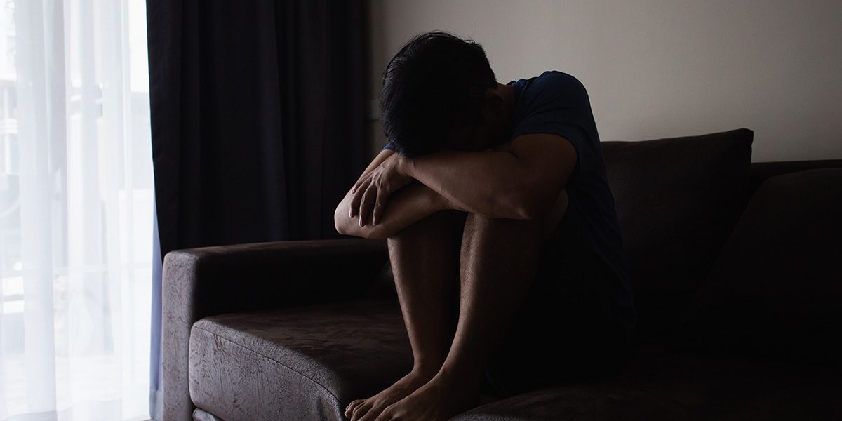 Empathy-Is-there-a-cost A young boy sitting with his face down suffering from psoriasis.