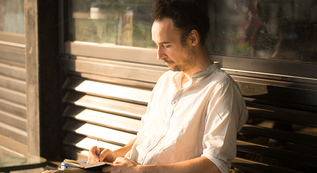 self-study-img man writing his inquiries in the book